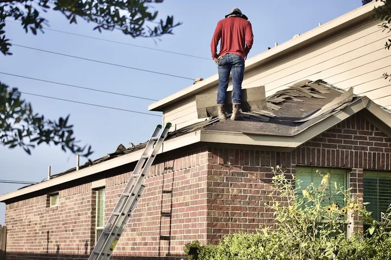 Professional roofer working on a residential roof in Village Seven